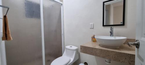 y baño con lavabo, aseo y espejo. en Casa con alberca Mirador 126, en Querétaro