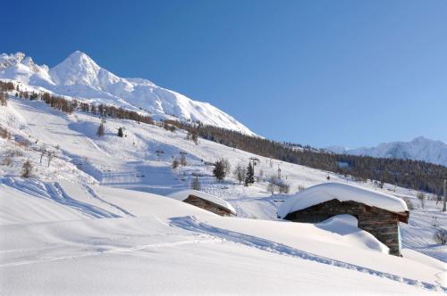 a snow covered slope with a mountain in the background at Résidence Odalys Edenarc in Arc 1800