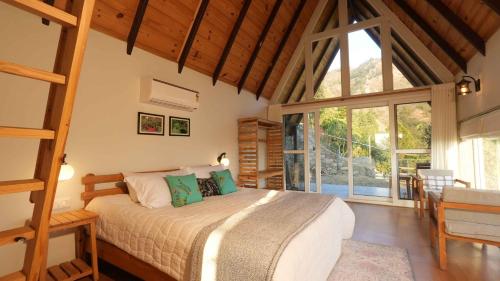 um quarto com uma cama e uma grande janela em amã Stays & Trails Godhuli Padam, Naukuchiatal em Nainital