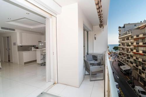 Cet appartement blanc offre une vue sur la ville. dans l'établissement Croisette 1 mn 2 BR w/ terrace Olam Properties, à Cannes
