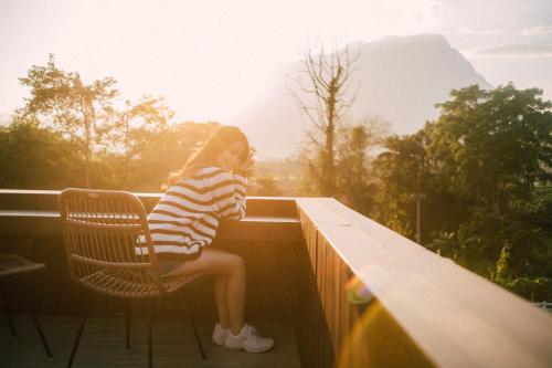 a young girl sitting in a chair on a balcony at The CAMPIAN in Chiang Mai