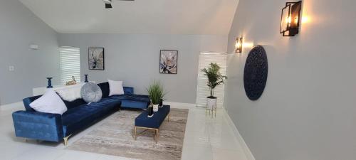 a living room with a blue couch and a table at Heart of Sunrise and Sawgrass in Sunrise