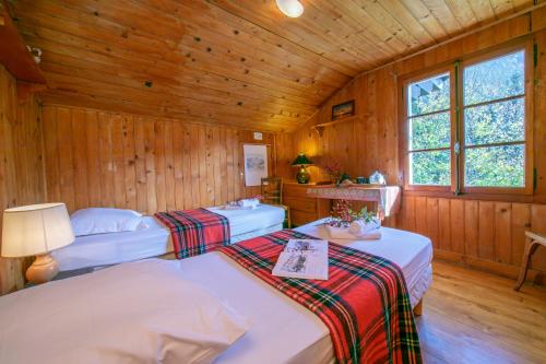 two beds in a room with wooden walls at Chalet L’eau vive - Happy Rentals in Chamonix-Mont-Blanc