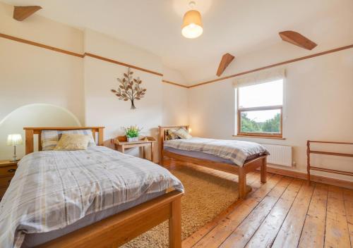a bedroom with two beds and a window at The Old Farmhouse in Ruabon