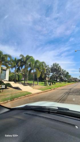 a car driving down a street with palm trees at Vista Bela in Aparecida de Goiania