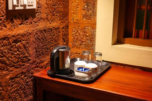 a coffee maker on a tray on a wooden table at Wild Courtyard Wayanad Resort in Wayanad