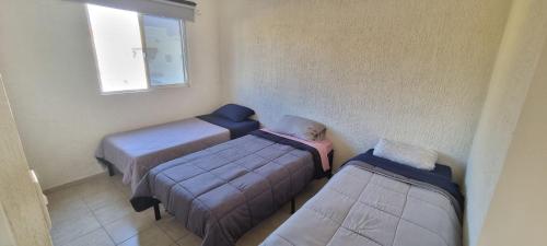 a room with three beds and a window at Casa con Alberca Alba in Querétaro