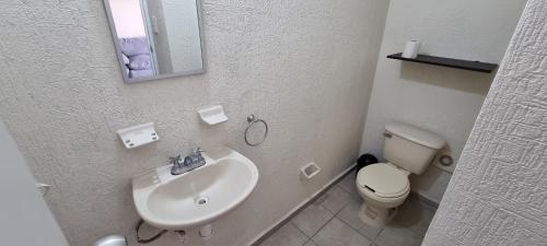 a bathroom with a sink and a toilet at Casa con Alberca Alba in Querétaro