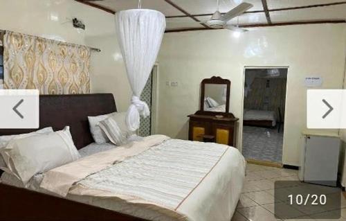 - une chambre avec un grand lit et un miroir dans l'établissement Limbas Luxury Appartements, à Bakau
