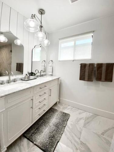 a white bathroom with a sink and a mirror at Newly remodeled beauty in Phoenix in Phoenix