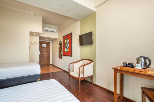 Habitación de hotel con cama, silla y escritorio. en 1O1 URBAN Jakarta Thamrin en Yakarta