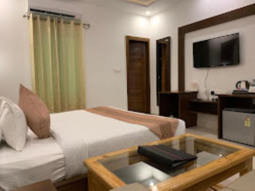 a hotel room with two beds and a coffee table at BLISS GANGA RISHIKESH , Uttarakhand in Rishīkesh