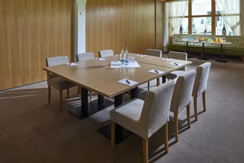 a conference room with a wooden table and chairs at Hostellerie am Schwarzsee in Bad-Schwarzsee
