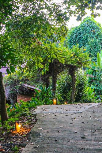 a walkway in a garden with trees and lights at Hillhouse - Koh Yao Noi in Ko Yao Noi