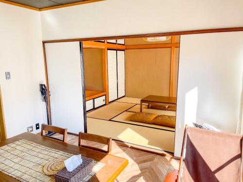 Habitación pequeña con mesa y habitación con cama en 【MeTeL】窓辺から壮大な富士が拝める。リノベーション済み一等貸し宿泊施設 en Nishikatsuracho