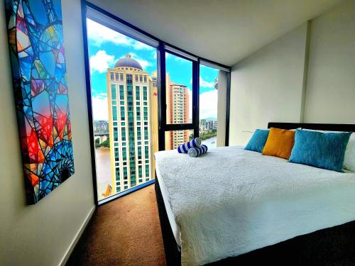 a bedroom with a bed with a view of a building at Great location and amazing views in Brisbane