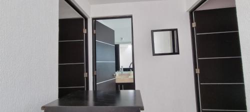 a bathroom with a mirror and a table and a sink at Casa con alberca Lomas de San Pedro in Querétaro