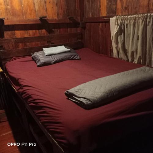 a large bed in a room with a red blanket at Do Dee cafe in Bangkok