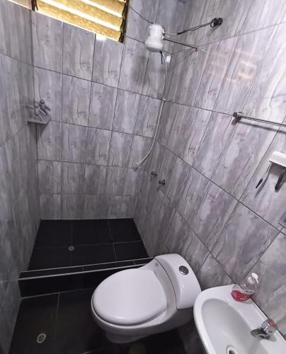a bathroom with a white toilet and a sink at Habitación en Cajamarca in Cajamarca