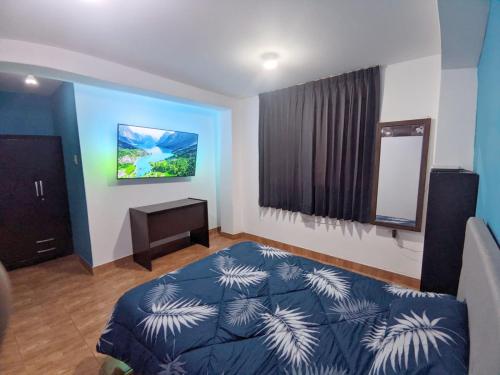 ein Schlafzimmer mit einem blauen Bett und einem Spiegel in der Unterkunft Habitación en Cajamarca in Cajamarca