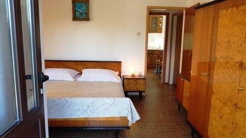 a bedroom with a bed and a table with a lamp at Apartments Zvone - at the water front in Veli Rat
