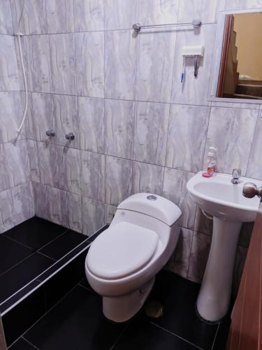 a bathroom with a toilet and a sink at Habitación en Cajamarca in Cajamarca