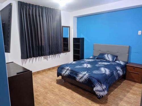 ein blaues Schlafzimmer mit einem Bett und einer blauen Wand in der Unterkunft Habitación en Cajamarca in Cajamarca