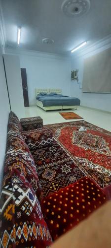 a room with a couch with a rug on the floor at العنبرية2 in Al Madinah