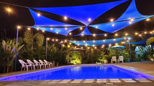 a pool at night with lights and chairs around it at Hidden Palms Inn & Resort Quadruple in San Juan