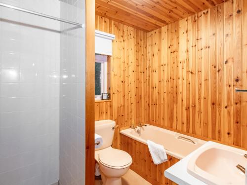 a bathroom with a toilet and a tub and a sink at Smiddy Cottage in Alyth