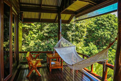 a hammock on the porch of a house at Hillhouse - Koh Yao Noi in Ko Yao Noi