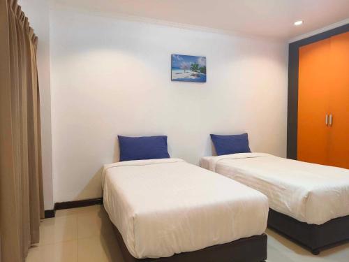 - 2 lits dans une chambre d'hôtel avec des oreillers bleus dans l'établissement Jt Place Buriram, à Buriram