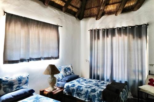 a bedroom with a bed and a window with curtains at Rhinos Rest in Marloth Park