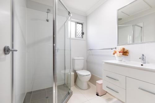 a bathroom with a toilet and a glass shower at Super Host, Well Presented with Wi-Fi! in Brisbane