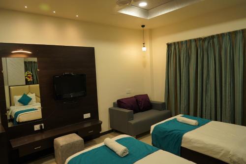 a hotel room with two beds and a television at Marshall The Grand Hotel in Ahmedabad