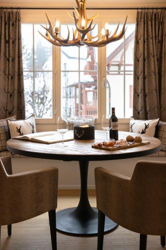 a table with a plate of food and wine glasses at Hotel Adula in Flims