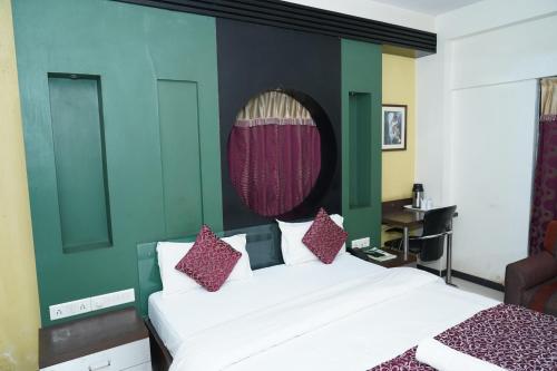 a bedroom with a white bed and a green wall at Marshall The Grand Hotel in Ahmedabad