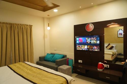um quarto de hotel com uma cama e um sofá em Marshall The Grand Hotel em Ahmedabad