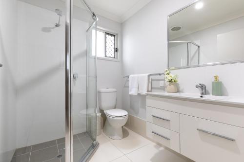 a white bathroom with a toilet and a shower at Super Host and New Listing in Brisbane