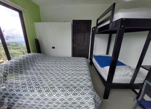 1 dormitorio con 2 literas y ventana en Apartamentito moderno con vista en Monteverde, en Cebadilla