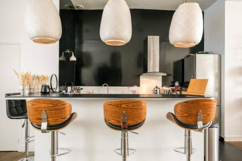 une cuisine avec un comptoir et des tabourets dans l'établissement Amazing Premium flat, fantastic location, 1290 Sqf, à Paris