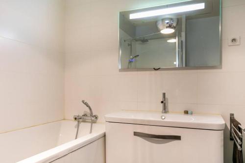 une salle de bain avec un lavabo, un miroir et une baignoire dans l'établissement Amazing Premium flat, fantastic location, 1290 Sqf, à Paris