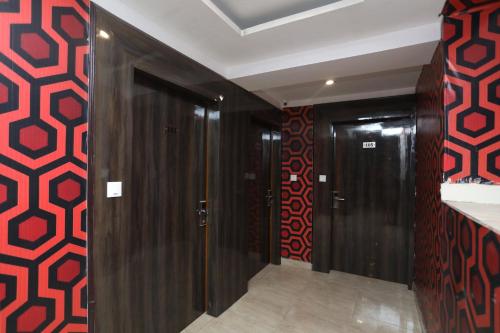 OYO Hotel Maan في جورجاون: مدخل مع أبواب خشبية وجدران حمراء وسوداء