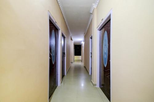 einen Flur mit einem langen Korridor mit einer Uhr an der Wand in der Unterkunft Ekora Resort in Hatikhuli