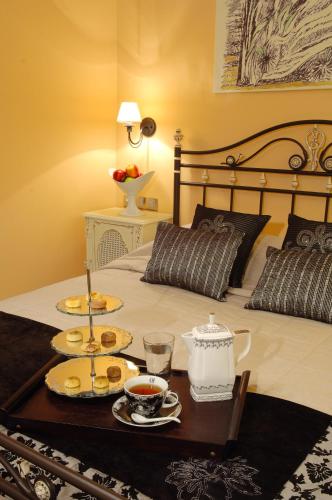 a bed with a tray of food on it at Olympic Fashion Hotels in Athens