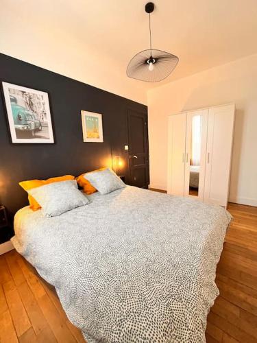 une chambre avec un grand lit avec un mur noir dans l'établissement Cosy appartment close to train station, Paris and CDG airport, à Aulnay-sous-Bois