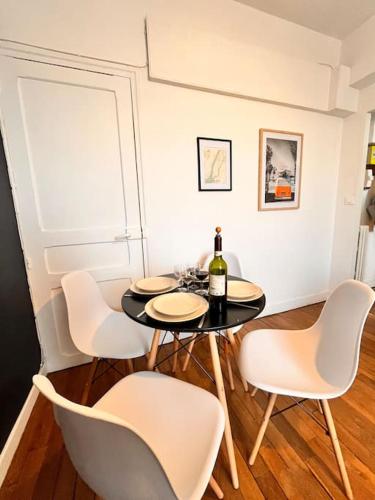 - une salle à manger avec une table et une bouteille de vin dans l'établissement Cosy appartment close to train station, Paris and CDG airport, à Aulnay-sous-Bois