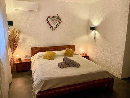 1 dormitorio con 1 cama con una corona en la pared en La Kaz Caleepso, en La Possession