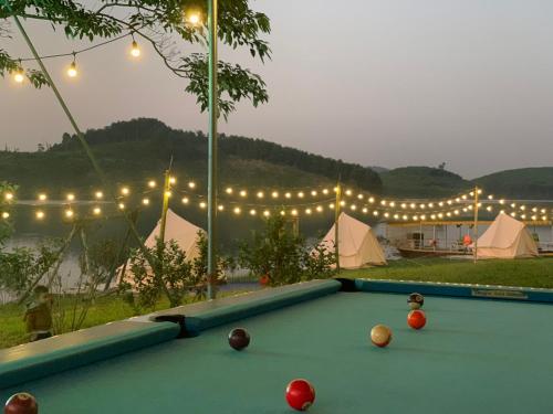een pooltafel in een tuin met verlichting en tenten bij Đảo Chè Thanh Chương - Điếu Cày Travel in Trai Ðỏ