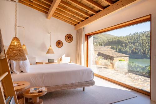 a bedroom with a bed and a large window at DOURWIN - Riverside Suites - Adults Only in Penafiel